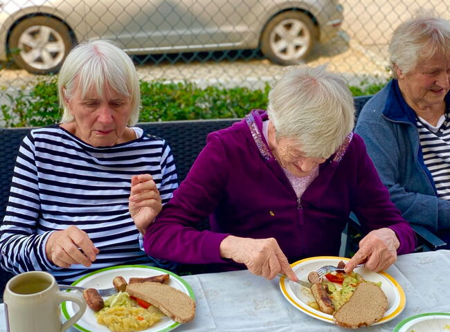 Bewohner zusammen beim Bratwurstessen