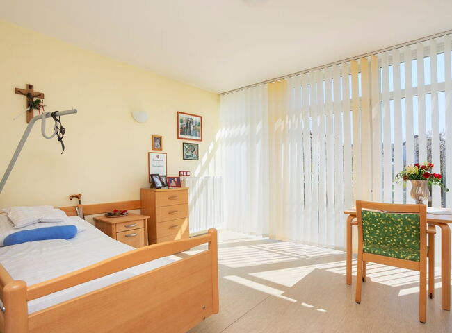 Blick in ein bewohntes Zimmer mit Bett und Möbeln