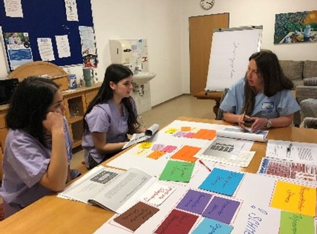 Azubis lernen Pflegebegriffe anhand von farbigen Karten