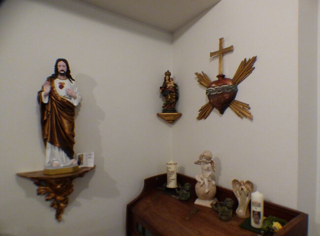 Devotionalien hängen an der Wand und stehen auf einem Schrank