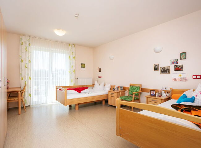 Blick in ein bewohntes Zimmer mit Bett und Möbeln