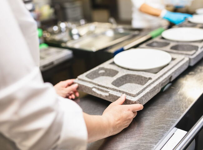 Teller werden in eine Warmhaltebox aus Styropor gerichtet