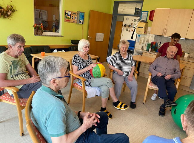 Bewohner sitzen zusammen im Stuhlkreis